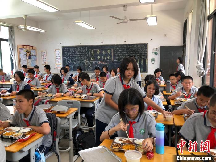 厦门六中初中部学生中午放学后分发学校配餐。　吴如宇 摄