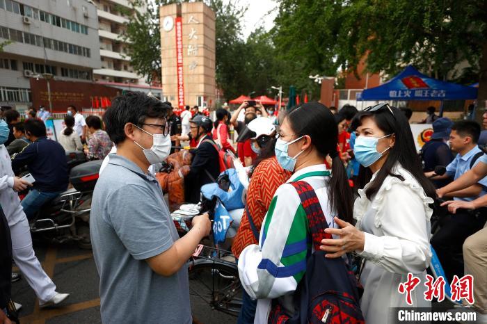 2021年中国高考7日拉开序幕。图为中国人民大学附属中学考点门前家长、师长、学长送考。　富田 摄