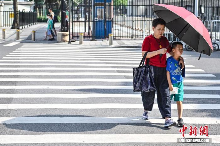 5月9日，广东省广州市，行人撑伞遮挡阳光。当日，广州市气象台发布了高温黄色预警信号，这是今年广州市气象台发布的首个高温预警信号。 中新社记者 陈骥旻 摄