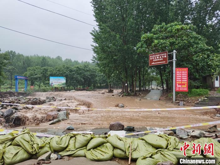 济源市思礼镇九里沟，部分路段已被山上的滚石断枝和高水位洪水阻断。　图片来源：济源市消防救援支队 摄