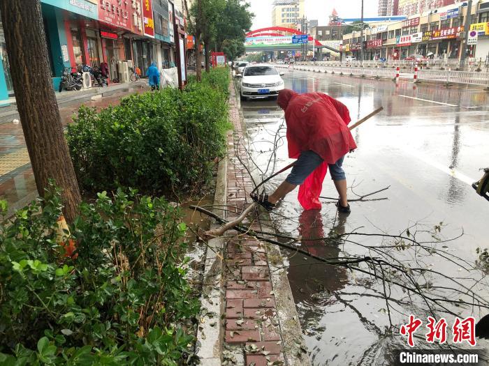 图为易县住建局工作人员对雨后的街道进行清理维护。　刘敬 　摄