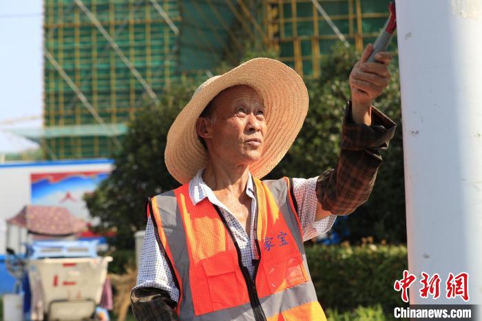 7月14日，在合肥庐阳经济开发区连水路与丽水路交口，环卫工人正在清扫小广告。　赵明 摄