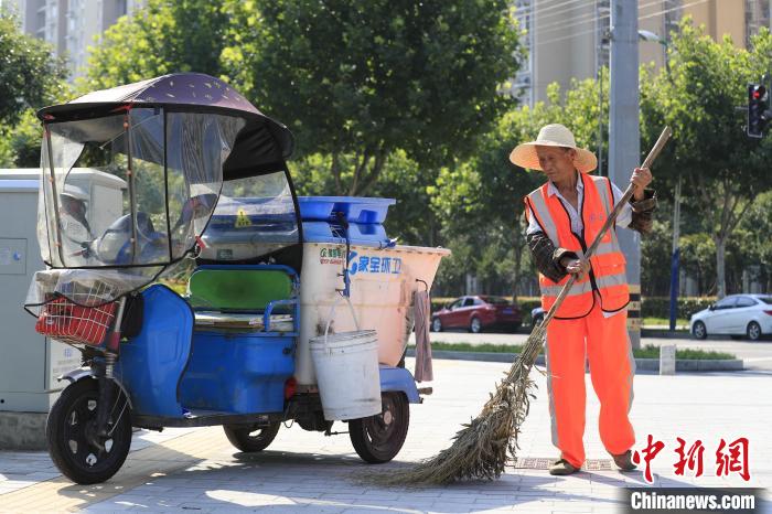 7月14日，在合肥庐阳经济开发区连水路与丽水路交口，环卫工人正在清扫马路卫生。　赵明 摄