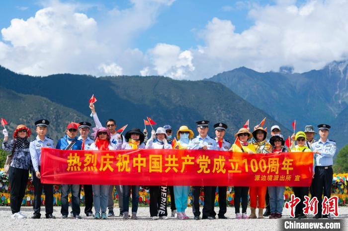 图为民警与游客合影。　江才云旦 摄