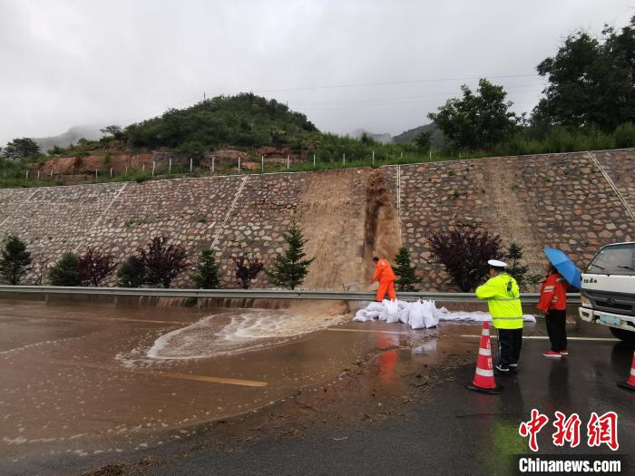 图为洪水裹挟着泥浆倾泻至高速公路路面。　高速交警供图