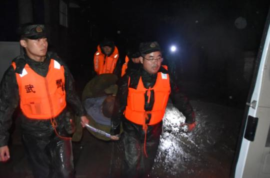 暴雨中，他们抬着大爷、抱着娃……