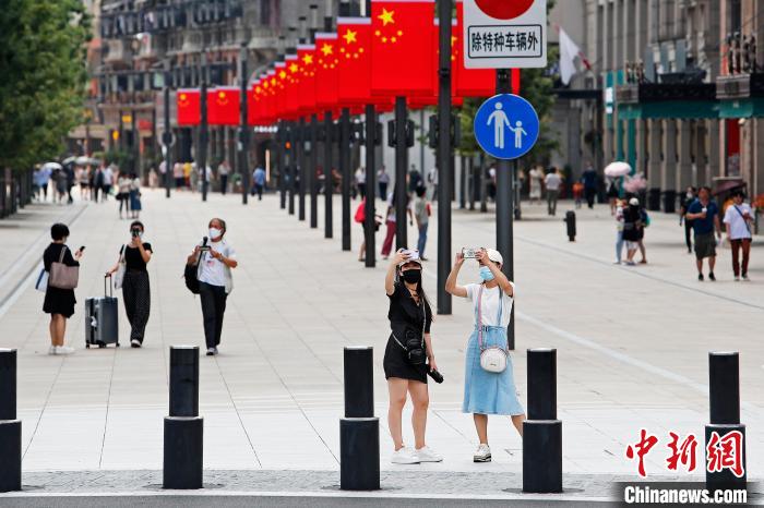 游客冒着高温在南京东路步行街上游玩。　殷立勤 摄