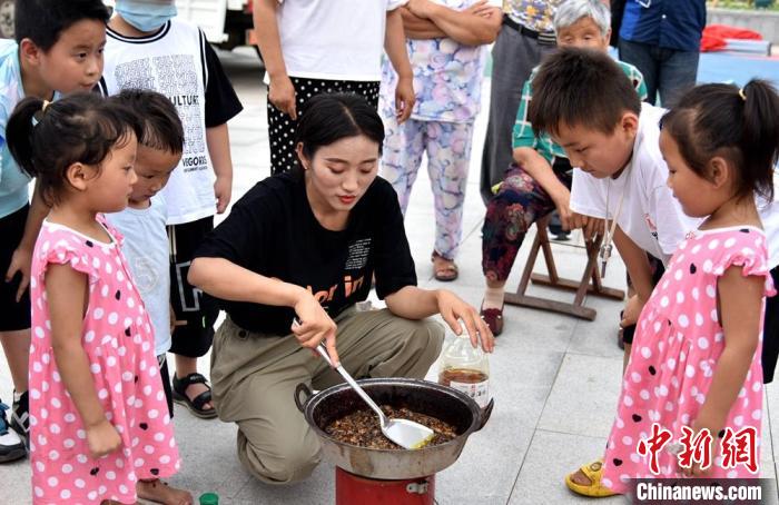 孩子们围在煎制金蝉现场，眼巴巴地等着美食出锅。　朱志庚 摄