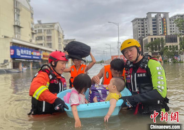 7月25日，台风“烟花”致浙江宁波洞桥发生洪涝，当地消防救援指战员沿街营救、疏散被困群众。　杨洋 摄