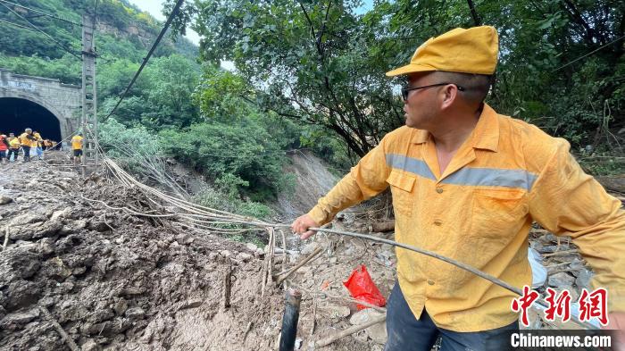 图为铁路职工顶高温、战水害坚守在抢修现场。　赵庆 摄