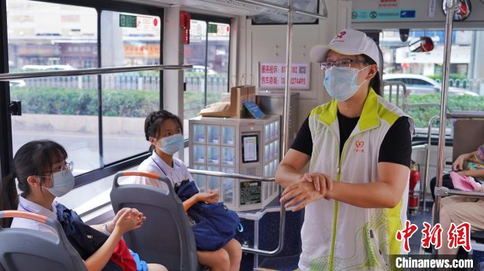 志愿者在公交车上为考生提供志愿服务 共青团广州市委 供图