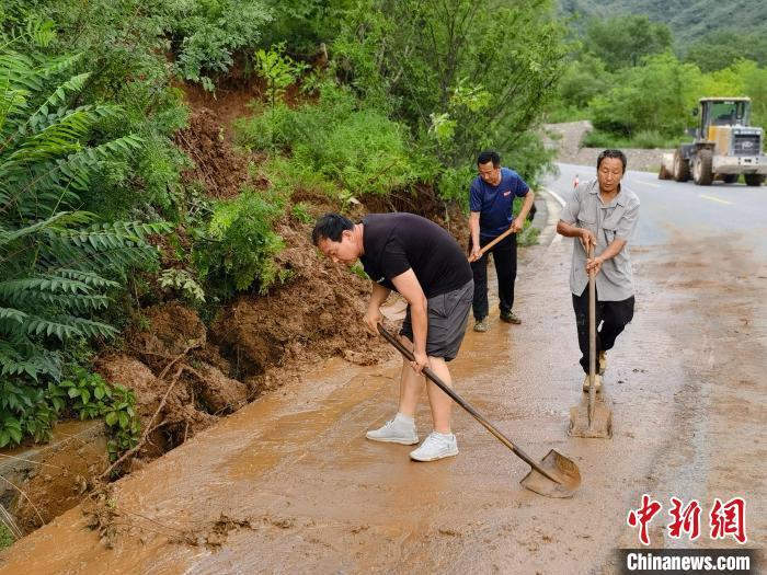 图为村民正在清理泥石路障。　徐巧明 摄