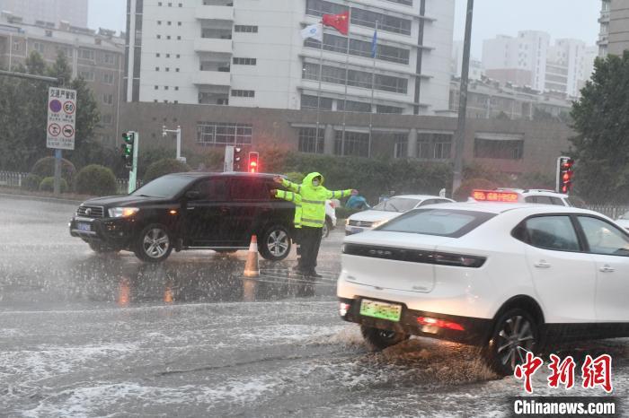 图为保定市公安交警在大雨中疏导交通。　保定市交警支队供图