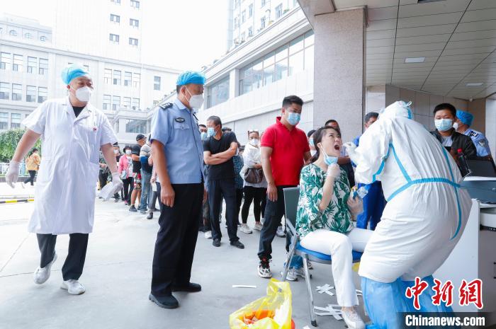 图为民警维持全员核酸检测现场秩序。　张扩 摄