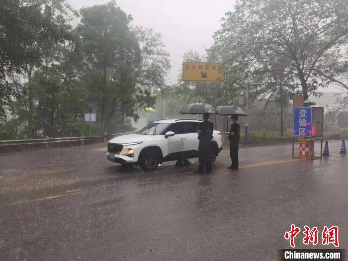 图为民警在雨中检查过往车辆。　红河边境管理支队供图