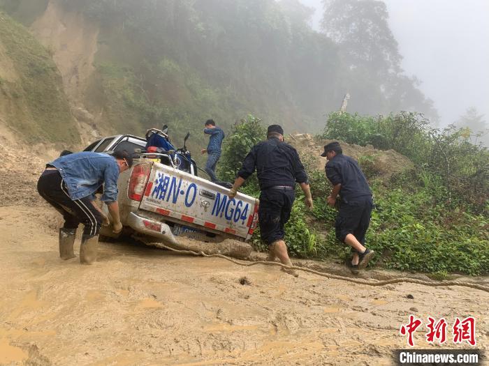 图为背崩边境派出所民警对被困车辆进行救援。　背崩边境派出所供图