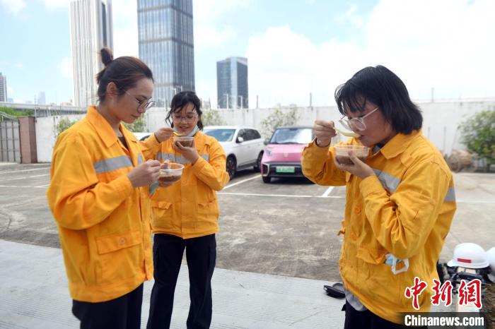 阮清兰(左)黄玉真(中)李行清(右)三位“90后”女职工在休息时吃八宝粥消暑。　蒋雪林 摄