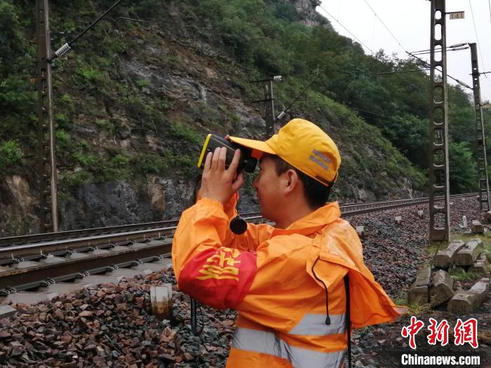 图为工作人员巡视铁路沿线地段，密切盯控线路情况。　王占军 摄