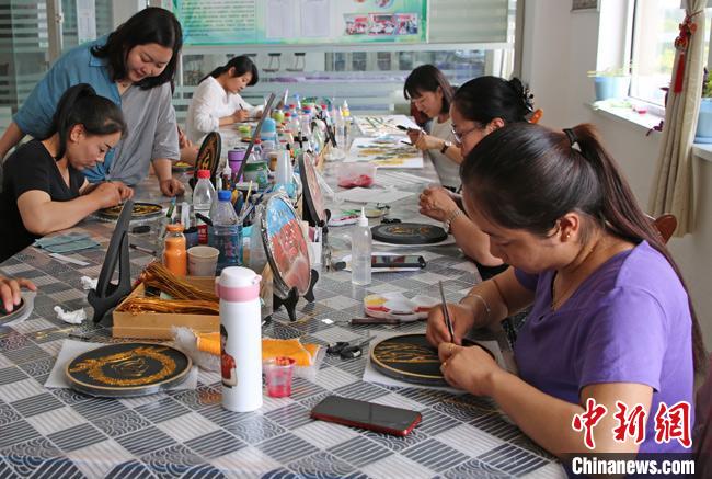 姚艳玲在甘肃高台县指导当地妇女制作手工艺品。　王娟梅 摄