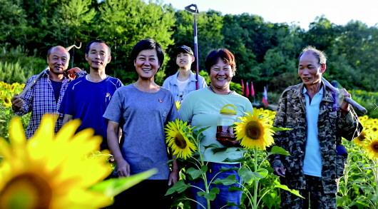 冷菊贞(左三)与村民在向日葵地的合影。受访者供图