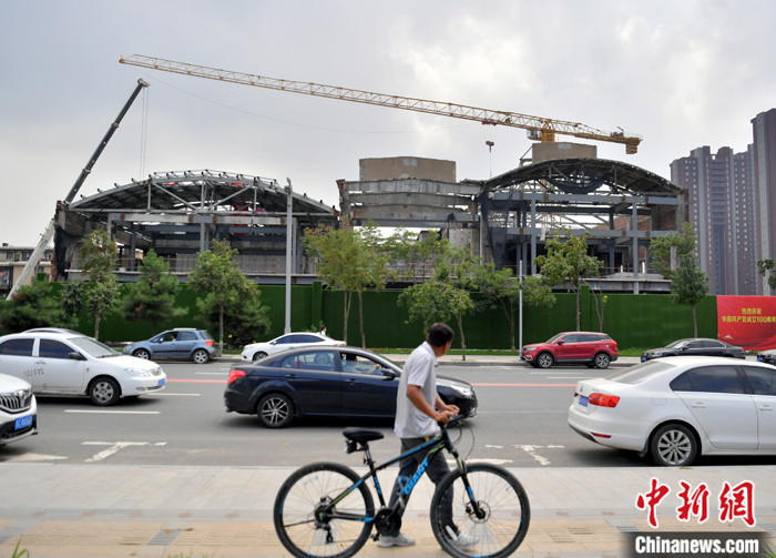 8月15日，吉林省长春市，一名市民从长春拖拉机厂工业遗址改造现场外经过。 中新社记者 张瑶　摄