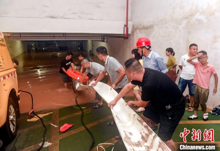 强降雨后，人们在金华一处地下停车场排涝。　李建林 摄