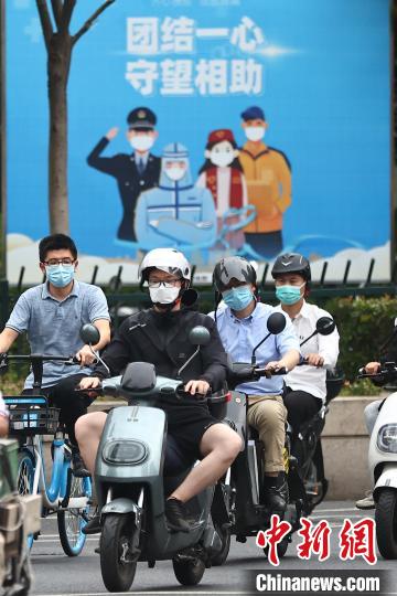 骑车的市民在南京街头经过。　泱波 摄