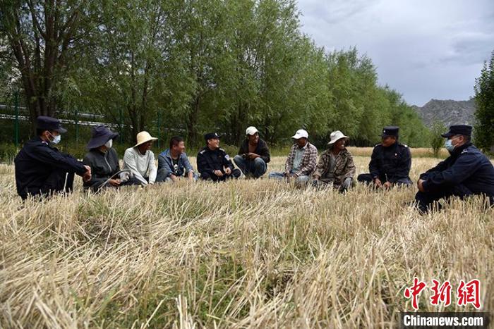 图为西藏拉萨出入境边防检查站民警与驻地群众在田间聊家常。　拉萨出入境边防检查站供图