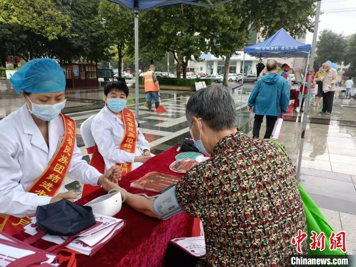 图为正定县2021年民族团结进步宣传月启动仪式上，志愿者为市民进行义诊。　王天译 摄