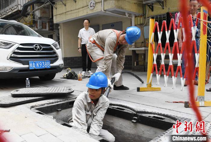 图为9月3日，福建福州供电公司施工人员在福州市台江新兴新村对小区老旧配电线路进行缆化改造。　陈蒸 摄