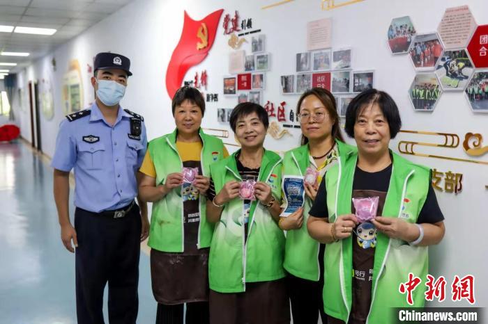 民警向社区工作者派发“反诈”月饼。　上海警方供图