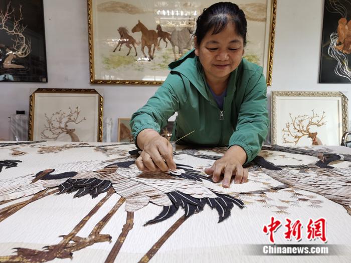 赵桂华在制作树皮画。 中新网记者 张尼 摄