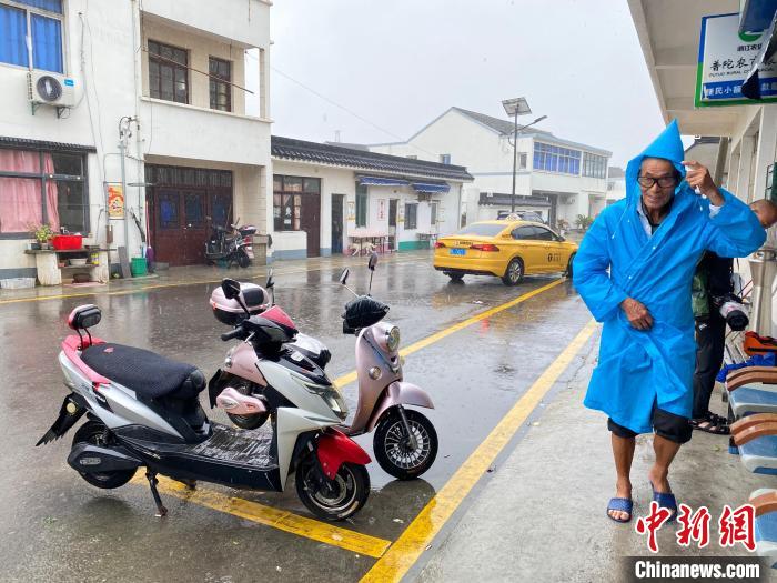 塘头村村民风雨中出行 李典 摄