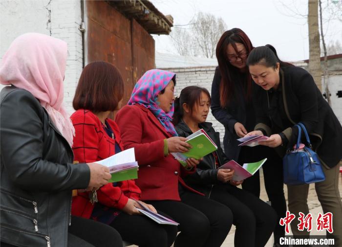 图为妇联干部为农村妇女讲解“两癌”防治知识。(资料图) 甘肃省政府妇儿工委办供图