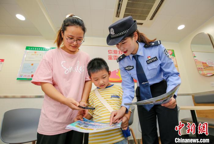 铜陵市公安局义安分局民警开展反诈骗宣传、指导市民安装“国家反诈中心”App。　陈晨 摄