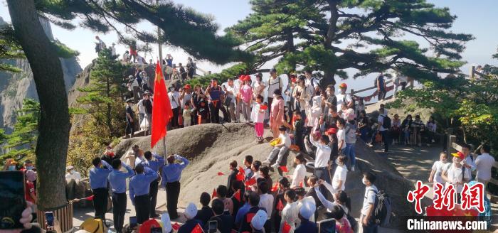 黄山迎客松前，游客和景区员工参加升国旗仪式 刘维刚 摄