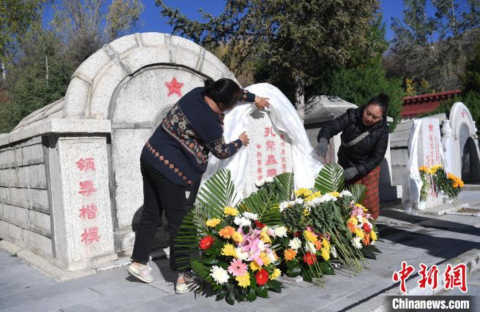 图为9月30日，在西藏自治区拉萨市烈士陵园，群众向孔繁森墓碑敬献鲜花、哈达。　贡嘎来松 摄