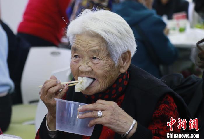 图为西宁市七一路西社区老人品尝水饺。　马铭言 摄