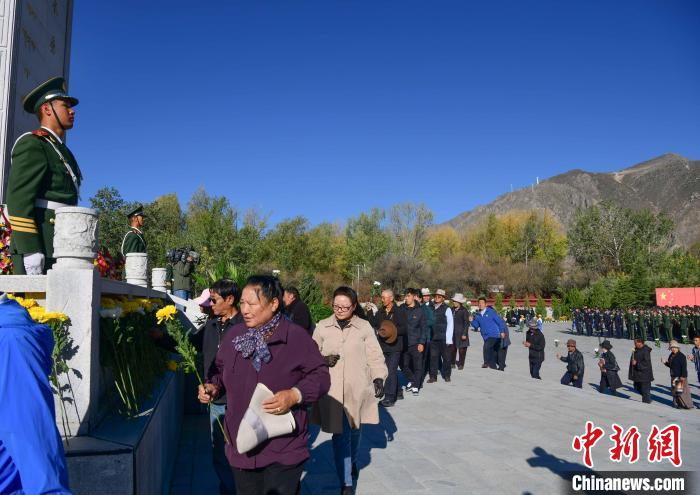 图为9月30日，在西藏自治区拉萨市烈士陵园，干部群众向革命烈士纪念碑献花。　贡嘎来松 摄