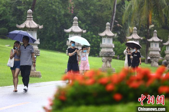 10月7日，游客在雨中游览三亚南山文化旅游区。　陈文武 摄