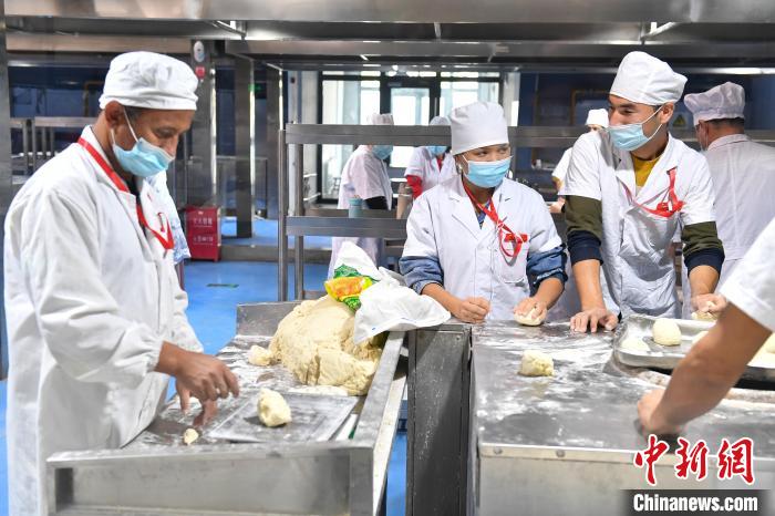 阿克苏馕产业园进行标准化管理，每个面团都需经过称重。　田雨昊 摄