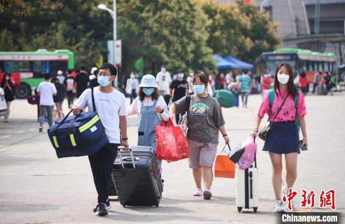 志愿者帮助新生搬运行李前往宿舍区。　泱波 摄