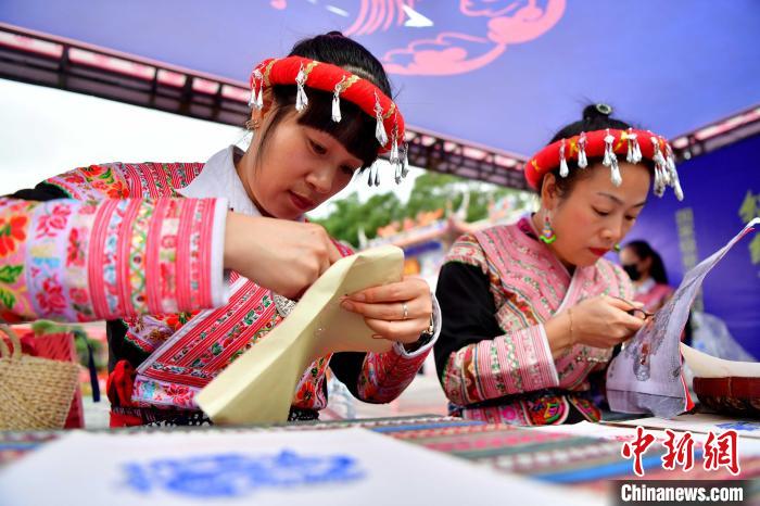 10月21日，畲族非遗文化传承人在民族团结进步宣传月主题活动上展示剪纸技艺。　张斌 摄