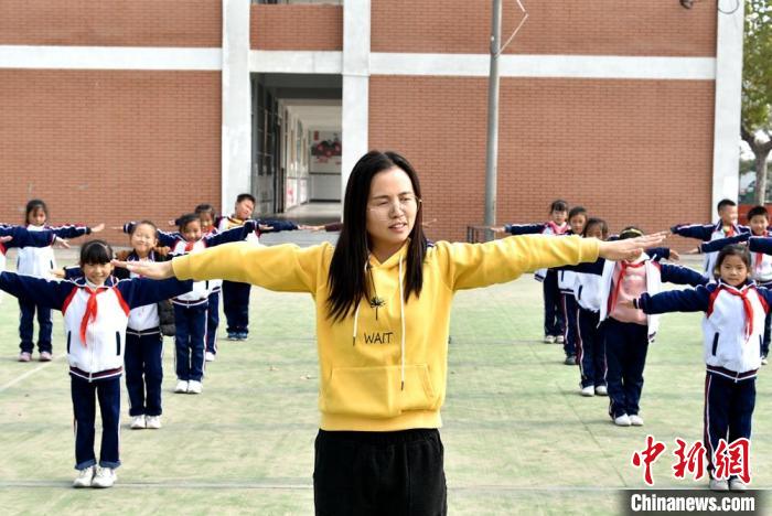 年轻教师李芳正在带领学生们上体育课。　朱志庚 摄