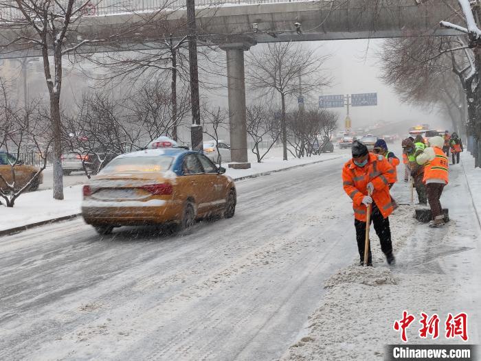 11月22日，环卫工人在哈尔滨街头冒雪清雪。　姜辉 摄