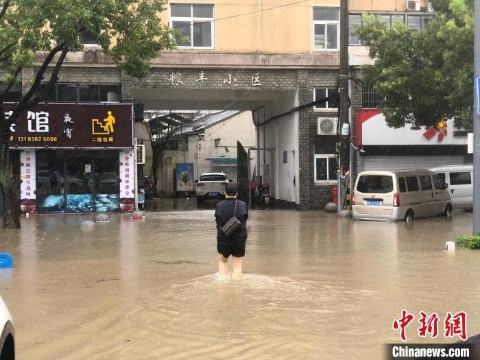 洞桥镇居民行走在积水中。　林波 摄