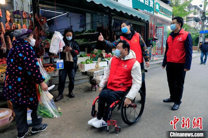 孙善永和其他志愿者对临街商铺进行劝导。　王磊 摄