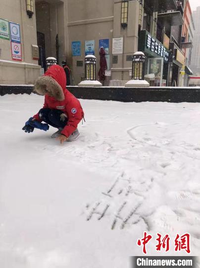 孩子在雪地里涂鸦。　姜辉 摄