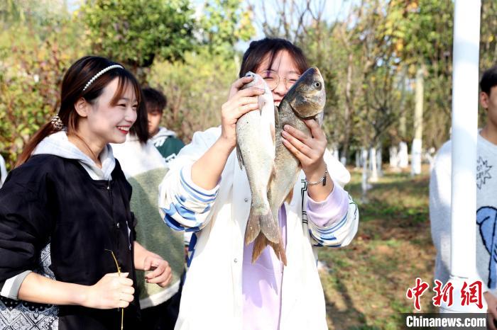 同学纷纷抓起鱼儿合影(10月30日拍摄) 钟炜 摄