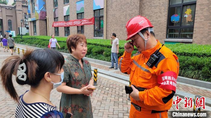 郑州市民李志彬(中)向国网四川电力驰援队伍表示感谢，眼中充满泪花，话语中一度哽咽。　曹志刚 摄